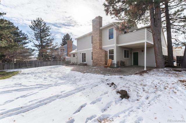 view of snow covered back of property