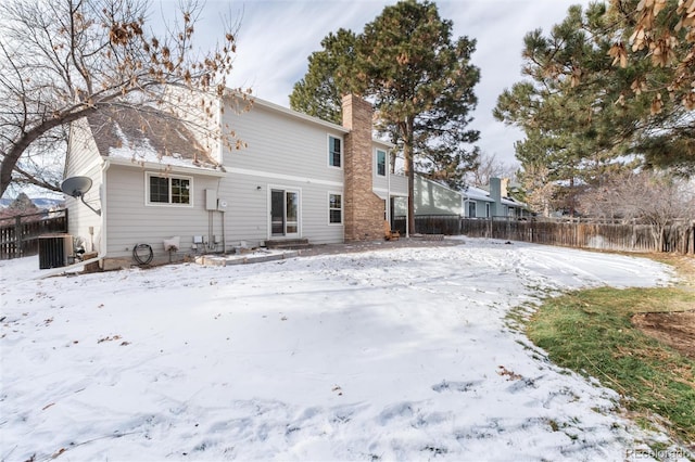 snow covered house with cooling unit