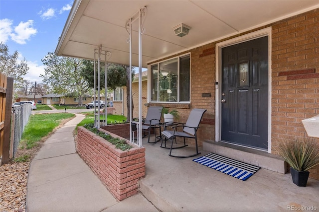 exterior space with brick siding and covered porch