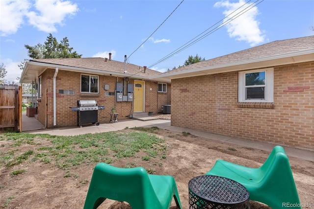 back of house with fence, brick siding, entry steps, cooling unit, and a patio area