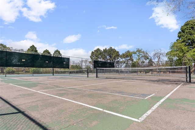 view of tennis court featuring fence