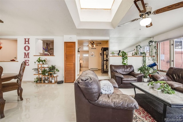 living room with a skylight and ceiling fan