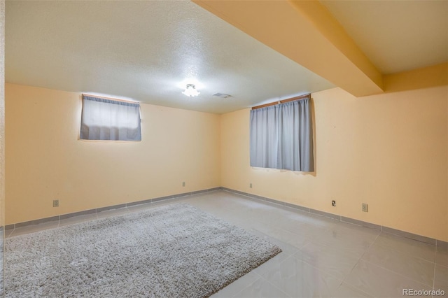 spare room featuring tile patterned flooring and a textured ceiling