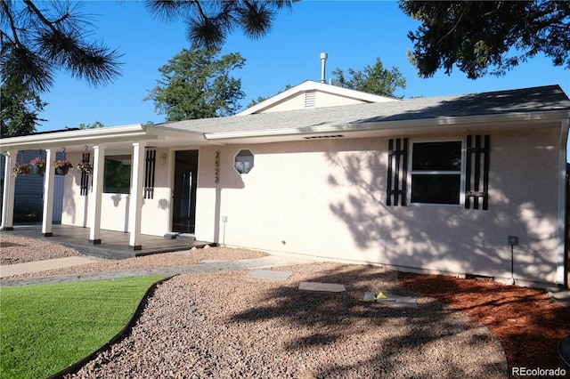 view of front of home with stucco siding, a porch, and a shingled roof