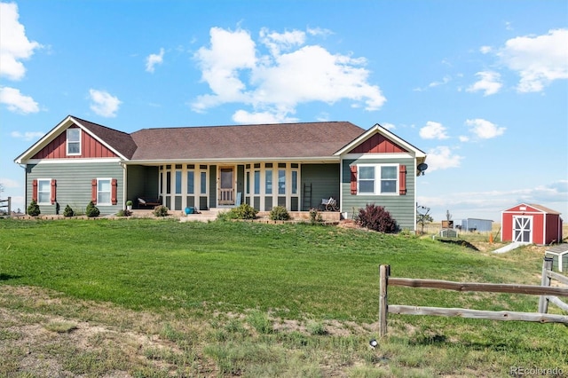 view of front of house featuring a front yard, a porch, and a storage unit