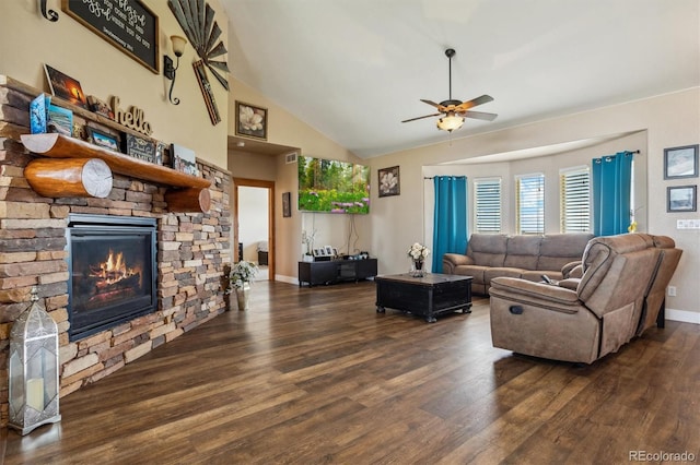 living room featuring lofted ceiling, a stone fireplace, dark hardwood / wood-style flooring, and ceiling fan