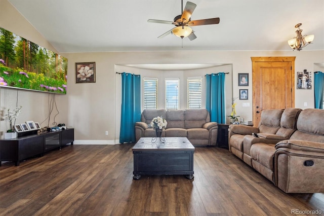 living room with ceiling fan with notable chandelier, dark hardwood / wood-style floors, and lofted ceiling