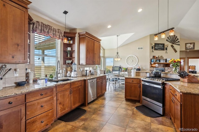 kitchen with decorative backsplash, sink, stainless steel appliances, and decorative light fixtures