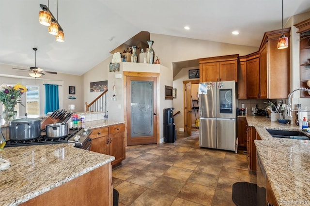 kitchen featuring pendant lighting, sink, appliances with stainless steel finishes, light stone countertops, and ceiling fan