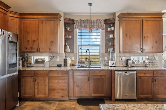 kitchen with backsplash, appliances with stainless steel finishes, decorative light fixtures, and sink