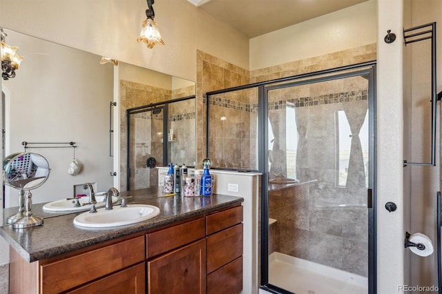 bathroom featuring a shower with shower door and vanity