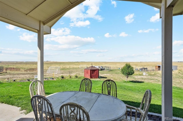 view of patio / terrace featuring a shed and a rural view