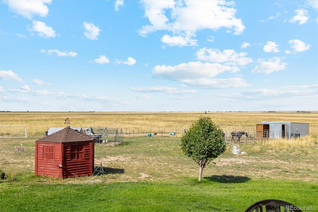 view of yard with a storage shed and a rural view