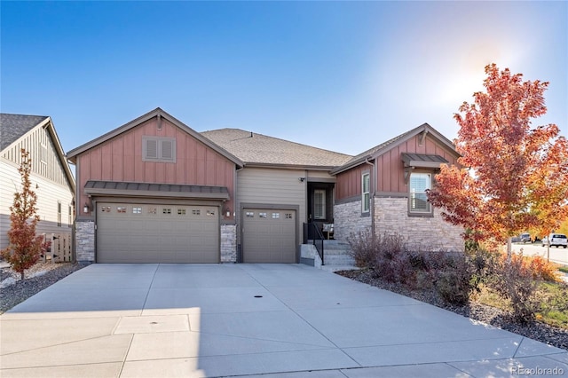 craftsman house with board and batten siding, concrete driveway, an attached garage, and stone siding