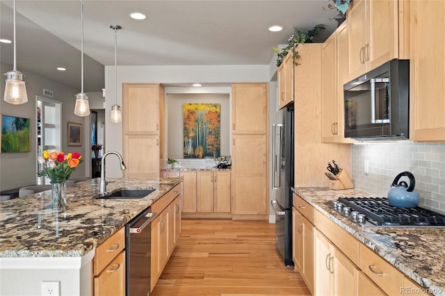 kitchen with light brown cabinets, appliances with stainless steel finishes, light wood-type flooring, and a sink