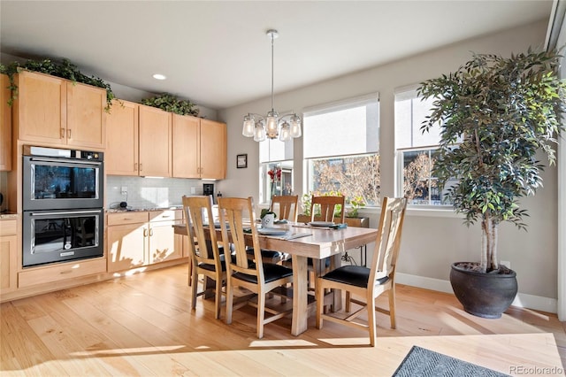 dining room featuring light wood-type flooring, a notable chandelier, baseboards, and recessed lighting