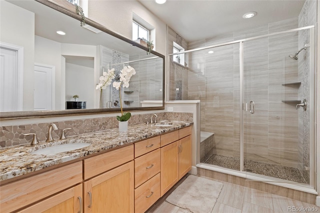 bathroom with recessed lighting, a sink, a shower stall, and double vanity