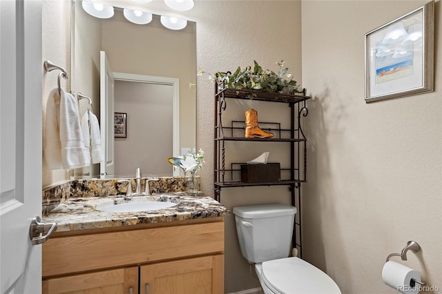 half bathroom featuring toilet and vanity