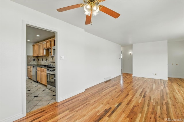 2441 E 93rd Pl, Thornton, CO 80229 - unfurnished living room with light wood-type flooring and a ceiling fan