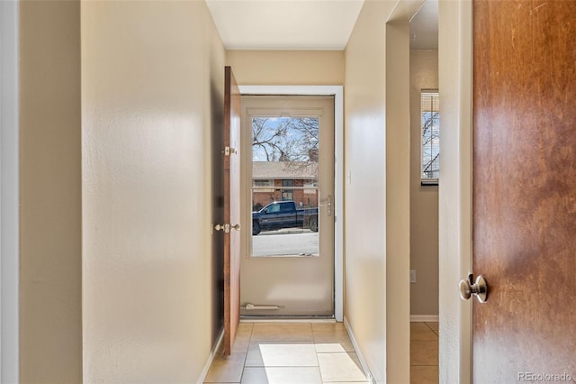 hallway featuring light tile patterned floors and baseboards