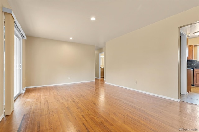 spare room with recessed lighting, baseboards, and light wood-type flooring