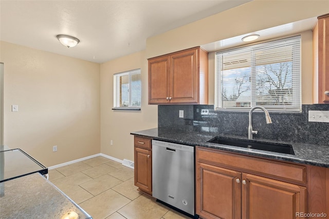 kitchen featuring a sink, stainless steel dishwasher, brown cabinetry, light tile patterned floors, and decorative backsplash