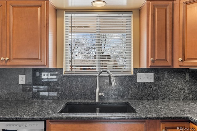 kitchen with a sink, dishwashing machine, backsplash, and brown cabinetry