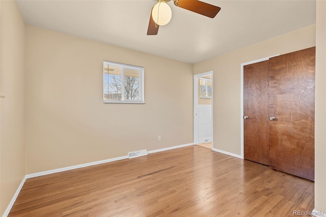 unfurnished bedroom with visible vents, baseboards, wood finished floors, and a ceiling fan