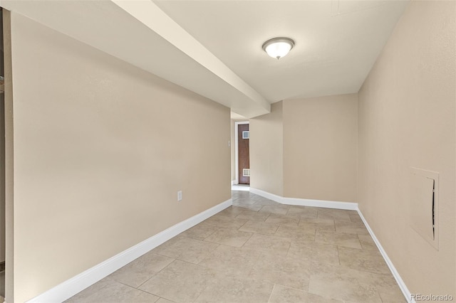 unfurnished room with baseboards