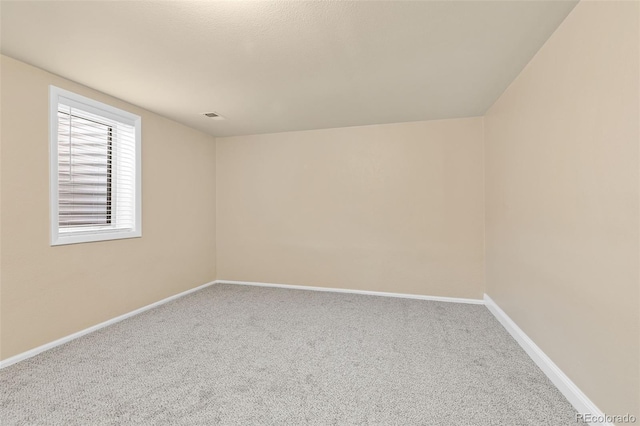 carpeted spare room with visible vents and baseboards