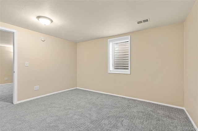 carpeted empty room with visible vents and baseboards