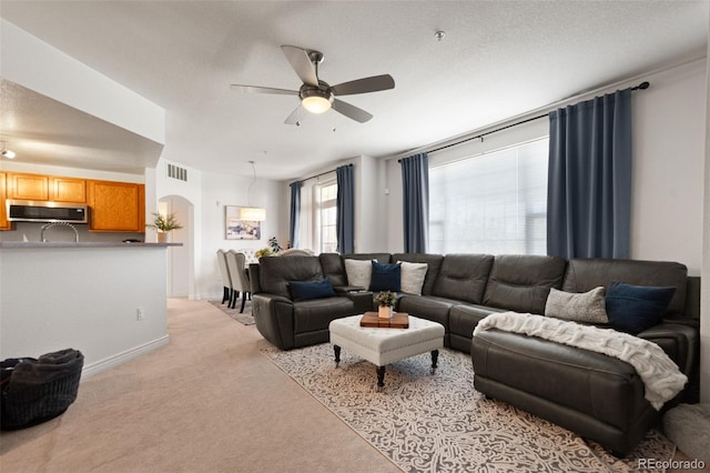 carpeted living room with ceiling fan