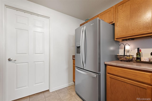 kitchen featuring light tile patterned flooring and stainless steel refrigerator with ice dispenser