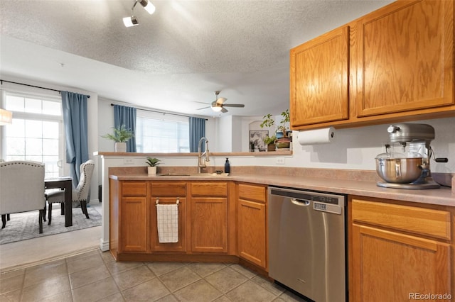 kitchen featuring a textured ceiling, dishwasher, sink, kitchen peninsula, and ceiling fan