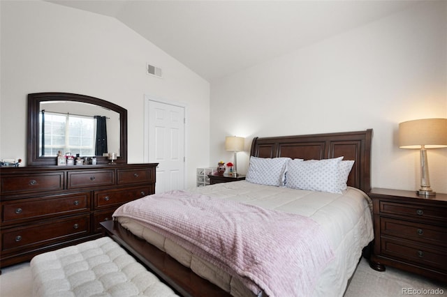 bedroom featuring light colored carpet and lofted ceiling