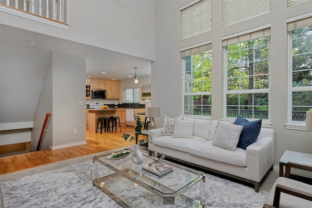 2500 Lexington St, Lafayette, CO 80026 - living room with light wood finished floors, a high ceiling, baseboards, and recessed lighting