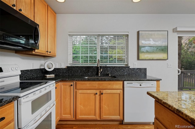 2500 Lexington St, Lafayette, CO 80026 - kitchen with white appliances, a sink, dark stone counters, light wood finished floors, and recessed lighting