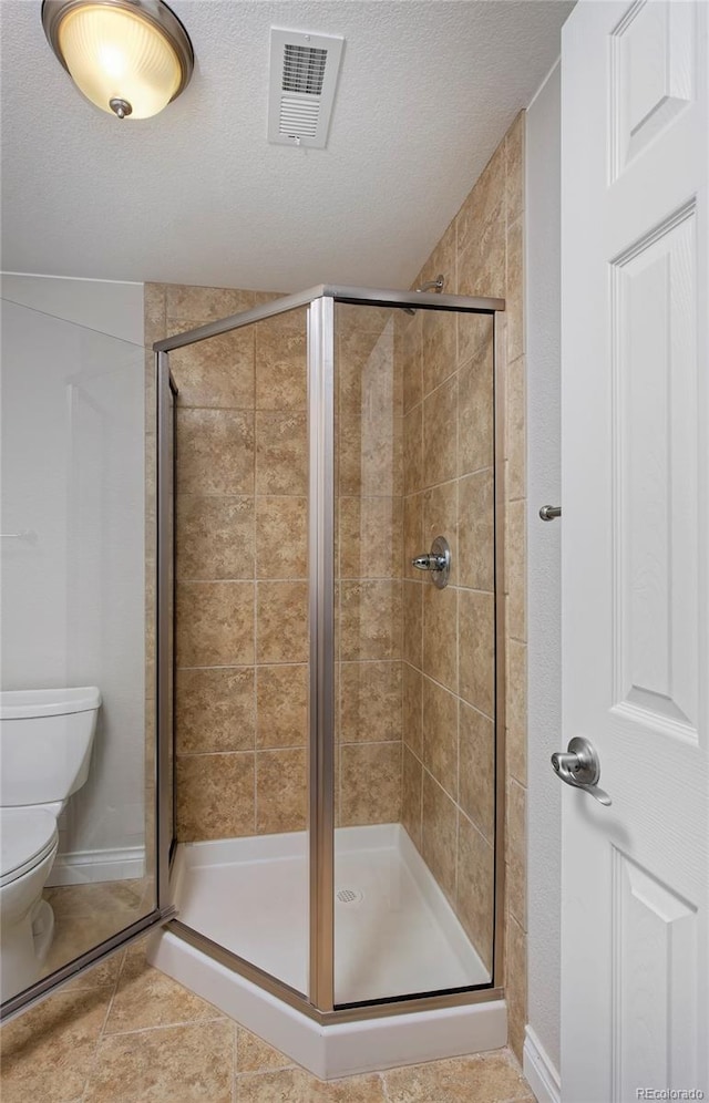 2500 Lexington St, Lafayette, CO 80026 - full bath with a shower stall, toilet, a textured ceiling, and tile patterned floors