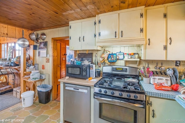 kitchen featuring wood ceiling, tile countertops, wooden walls, and stainless steel appliances