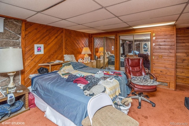 bedroom featuring carpet flooring, a closet, and wooden walls