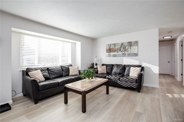 living area with visible vents, light wood-style flooring, and baseboards