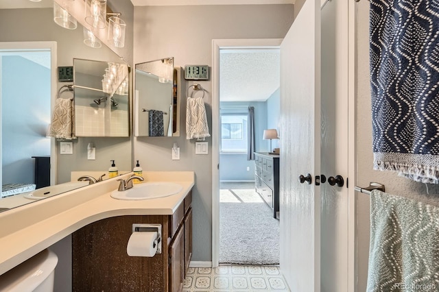 full bathroom with baseboards, vanity, and a textured ceiling