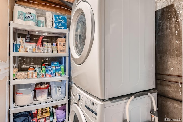 clothes washing area with stacked washer and dryer and laundry area