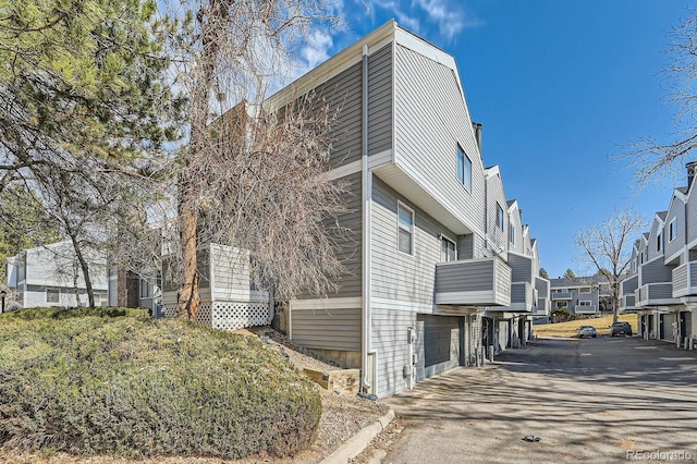 view of home's exterior with a garage, a residential view, and driveway