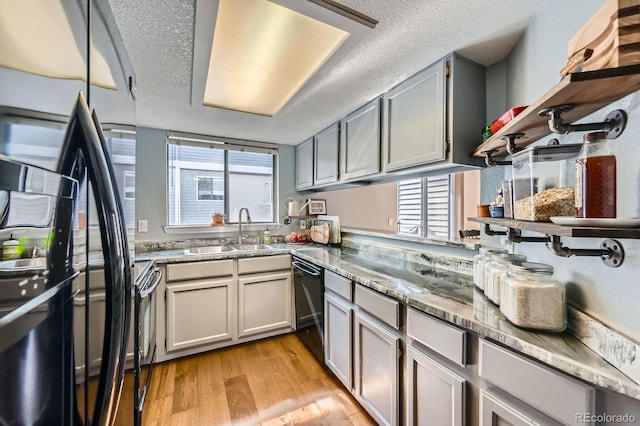 68 S Moline St, Aurora, CO 80012 - kitchen with black appliances, a sink, a textured ceiling, light wood-type flooring, and dark stone counters