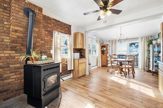 kitchen featuring decorative light fixtures, light brown cabinets, brick wall, ceiling fan with notable chandelier, and a baseboard radiator