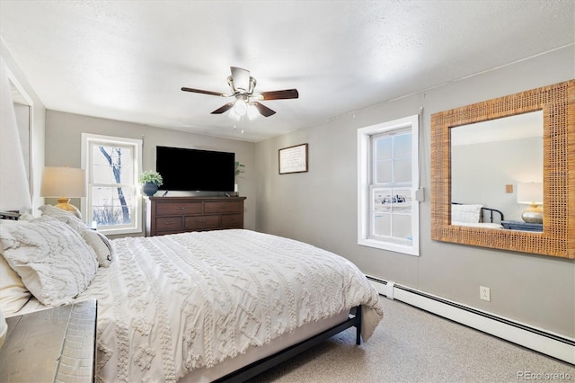 bedroom with ceiling fan, baseboard heating, and carpet floors