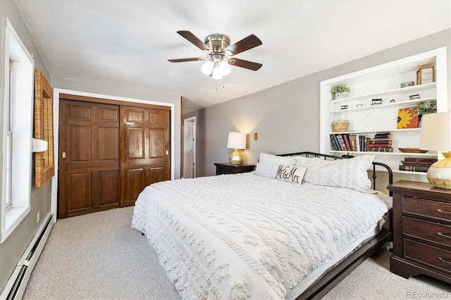 carpeted bedroom with ceiling fan, a baseboard heating unit, and a closet