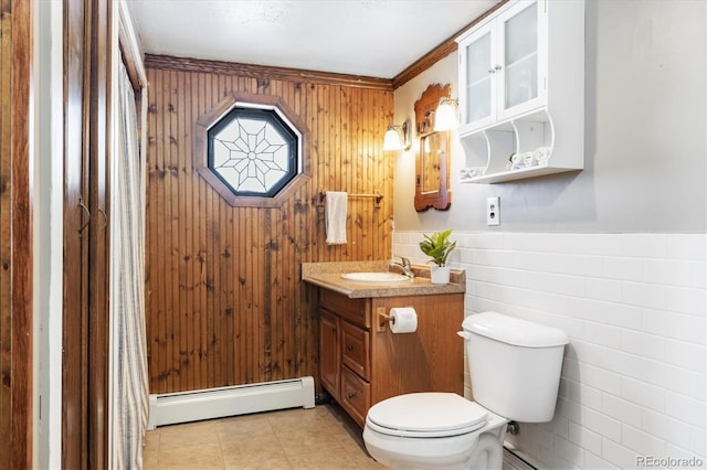 bathroom featuring toilet, vanity, a baseboard heating unit, tile walls, and tile patterned floors