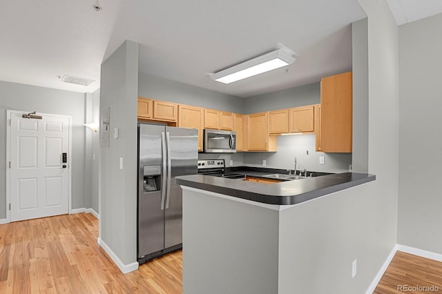 1780 N Washington St Unit 405, Denver, CO 80203 - kitchen with appliances with stainless steel finishes, light brown cabinets, dark countertops, a sink, and light wood-style flooring